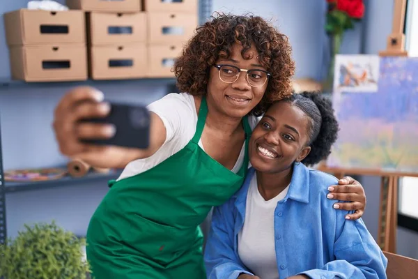 African american women teacher and student artist make selfie by smartphone at art studio