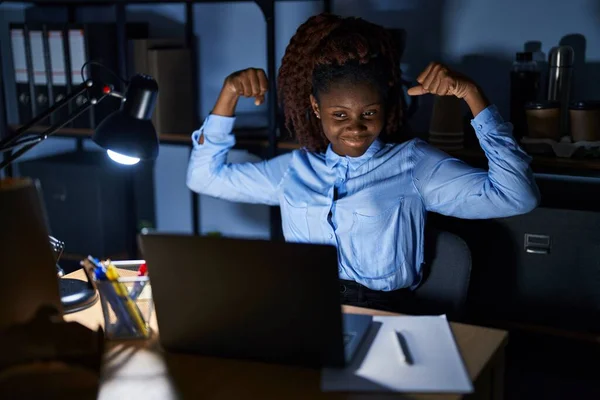 晚上在办公室工作的非洲女人露出臂膀肌肉 露出自豪的笑容 健身概念 — 图库照片