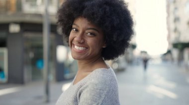 Sokakta kendine güvenen Afrikalı Amerikalı kadın gülümsüyor