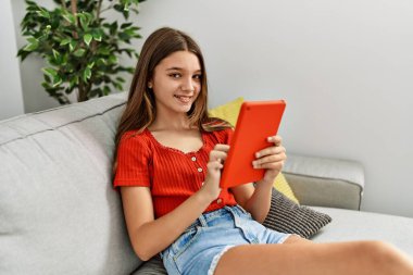 Evde dokunmatik ped kullanarak kendine güvenen sevimli bir kız.