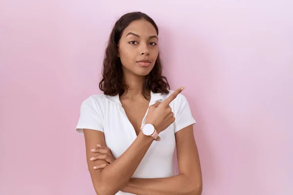 年轻的惊慌失措的女人穿着随意的白色T恤 手指头指向广告的侧面 严肃而沉着 — 图库照片