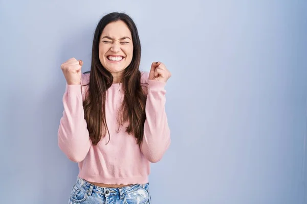 Young Brunette Woman Standing Blue Background Excited Success Arms Raised — 스톡 사진