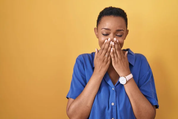 Африканская Американка Стоящая Жёлтом Фоне Смеявшись Смущённо Хихикая Прикрывая Рот — стоковое фото