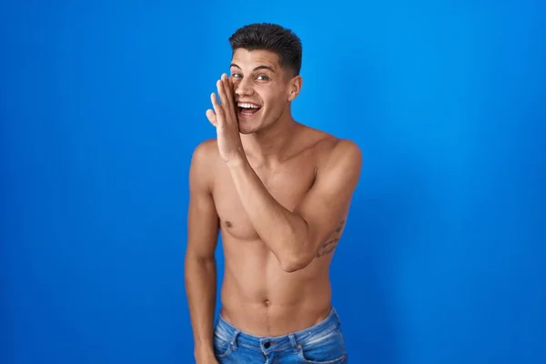 Молодой Латиноамериканец Стоящий Рубашки Синем Фоне Рука Руку Рассказывает Тайные — стоковое фото