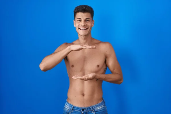 Joven Hombre Hispano Pie Sin Camisa Sobre Fondo Azul Gesticulando —  Fotos de Stock