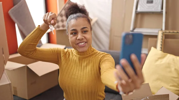 stock image Young african american woman smiling confident holding key doing video call at new home