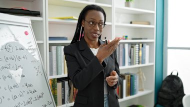 Afrika kökenli Amerikalı kadın öğretmen üniversite sınıfında matematik dersi veriyor.