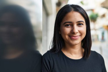 Sokakta kendine güvenen genç Latin kadın gülümsüyor