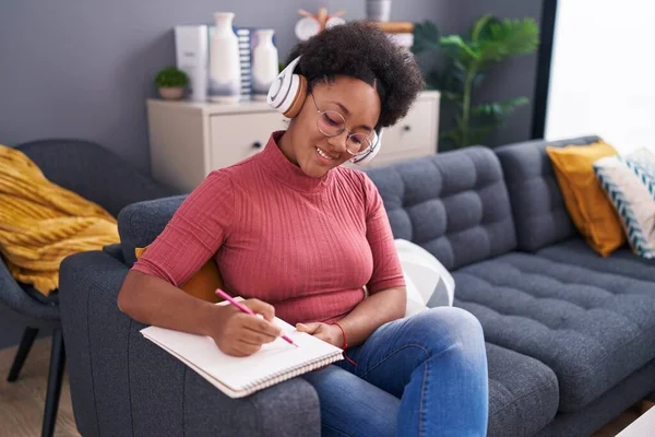 African American Woman Listening Music Writing Notebook Home — Foto de Stock