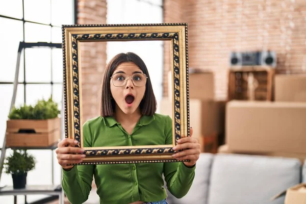 Young Hispanic Woman New Home Holding Empty Frame Afraid Shocked — Stock Photo, Image