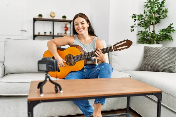年轻美丽的惊慌失措的女人在家里弹奏古典吉他录音录像 — 图库照片