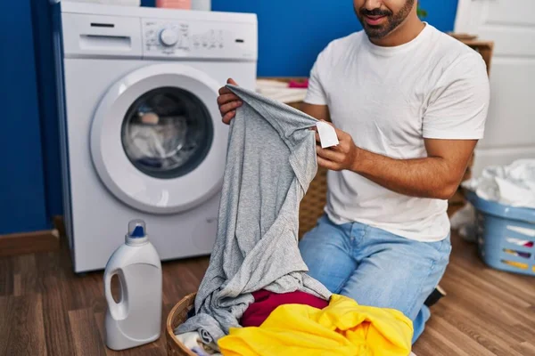 Ung Latinamerikan Man Tvätta Kläder Ser Skjorta Etikett Tvättstuga — Stockfoto