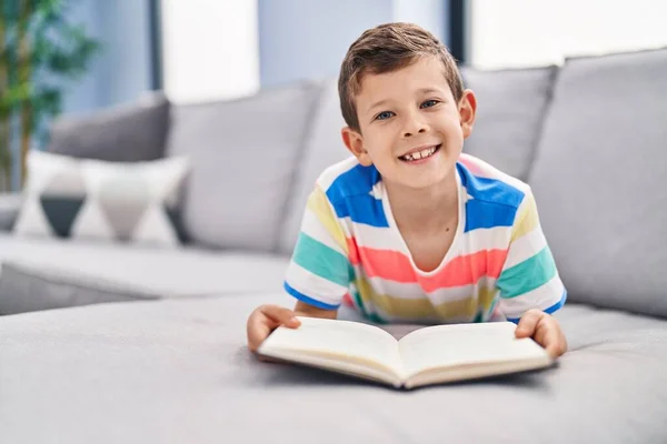 Blond Child Reading Book Sitting Sofa Home — Foto Stock