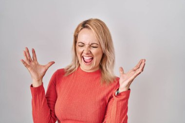 Sarışın kadın, izole edilmiş arka planda durup başarının çılgınlığını kutlarken kollarını kaldırmış, gözlerini kapatmış heyecanlı çığlıklar atıyordu. Kazanan konsept 