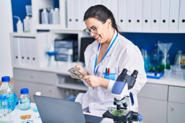 Genç İspanyol bilim kadını laboratuvarda dolar sayıyor.