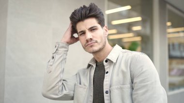 Sokakta ciddi bir ifadeyle duran İspanyol genç adam.