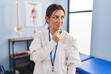 Ağrı kesici kliniğinde çalışan genç esmer kadın bir soru hakkında endişeli ve gergin bir şekilde düşünüyor. 