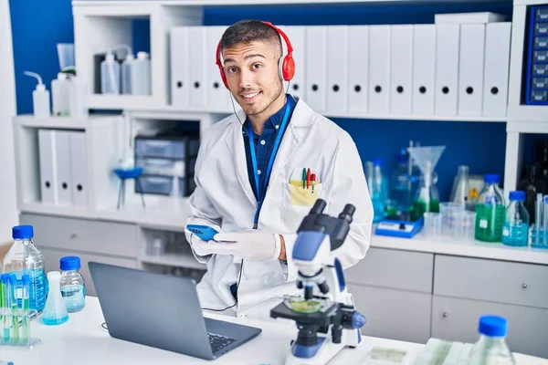 Young Hispanic Man Scientist Using Laptop Smartphone Laboratory — ストック写真