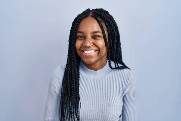 Afrikansk Amerikansk Kvinna Står Över Blå Bakgrund Blinkar Tittar Kameran — Stockfoto