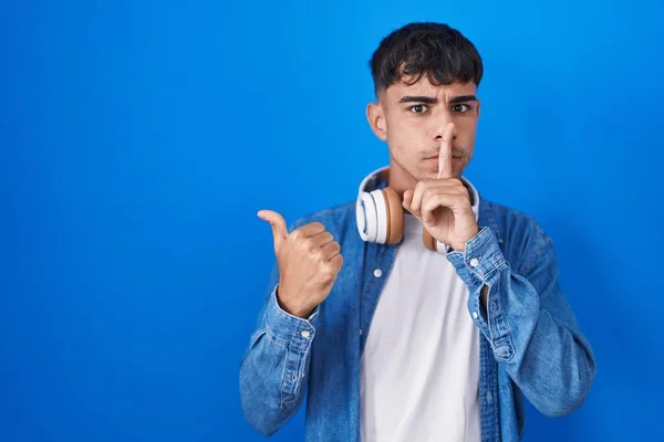 Junger Hispanischer Mann Der Vor Blauem Hintergrund Steht Und Darum — Stockfoto