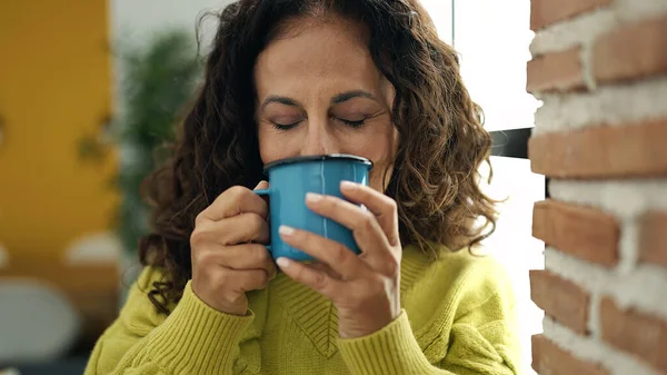 Middle Age Hispanic Woman Drinking Coffee Standing Home — Zdjęcie stockowe