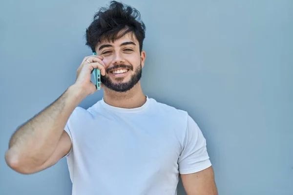 Молодой Латиноамериканец Улыбается Уверенно Разговаривая Смартфоне Белом Изолированном Фоне — стоковое фото