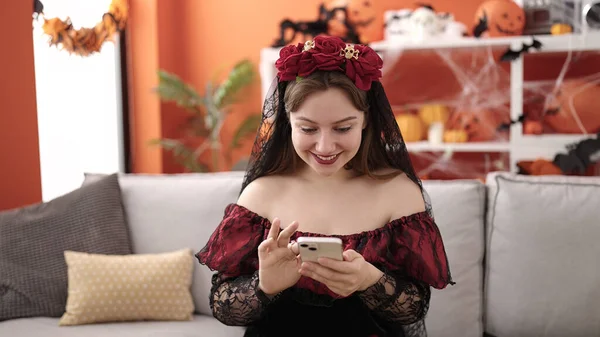 Young Blonde Woman Wearing Katrina Costume Using Smartphone Home — 스톡 사진