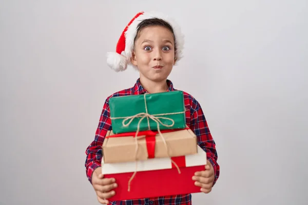 Pequeño Niño Hispano Con Sombrero Navidad Sosteniendo Regalos Hinchando Mejillas —  Fotos de Stock