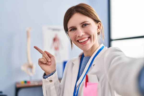 Jovem Fisioterapeuta Mulher Trabalhando Clínica Recuperação Dor Sorrindo Feliz Apontando — Fotografia de Stock