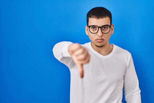年轻的阿拉伯男子身穿宽松的白色衬衫 戴着一副眼镜 看起来很不高兴 怒气冲冲地表示拒绝和负面的手势 不好的表达方式 — 图库照片
