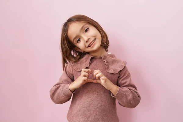 Kleines Hispanisches Mädchen Das Über Rosa Hintergrund Steht Und Verliebt — Stockfoto