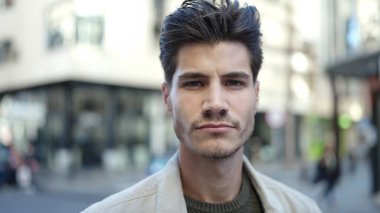 Sokakta ciddi bir ifadeyle duran İspanyol genç adam.