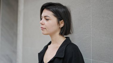 İzole edilmiş beyaz arka planda ciddi bir ifadeyle duran beyaz bir kadın.