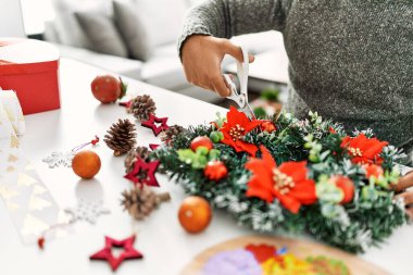 Genç İspanyol adam evde el yapımı Noel süsü yapıyor.