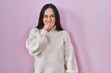 Pembe arka planda duran genç Güney Asyalı kadın pis ve iğrenç bir koku alıyor. Dayanılmaz bir koku. Nefesini burnunda tutuyor. Kötü kokuyor. 