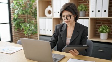 Young caucasian woman business worker using laptop and touchpad working at office