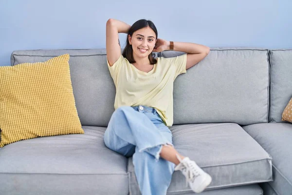 Young Hispanic Woman Relaxed Hands Head Sitting Sofa Home — Stockfoto