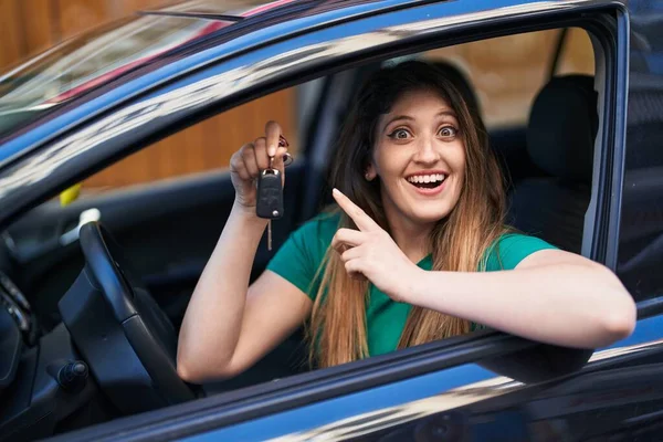 若いですブルネット女性保持キーの新しい車の笑顔でアイデアや質問を指差す指で幸せな顔 ナンバーワン — ストック写真