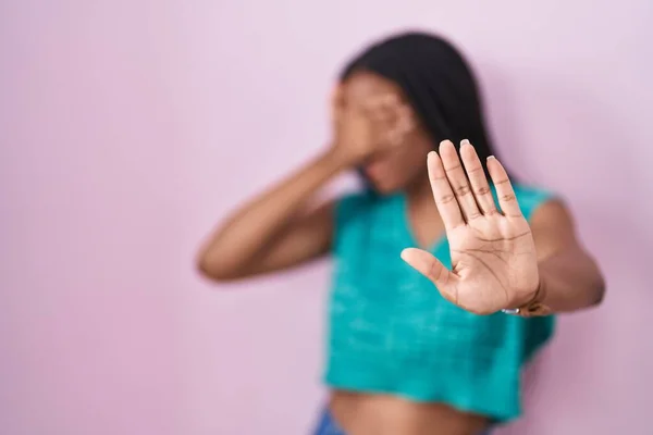 Молодой Африканский Американец Косичками Стоящими Розовом Фоне Закрывая Глаза Руками — стоковое фото