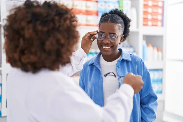 アフリカ系アメリカ人女性薬剤師と薬局で眼鏡をかける顧客 — ストック写真