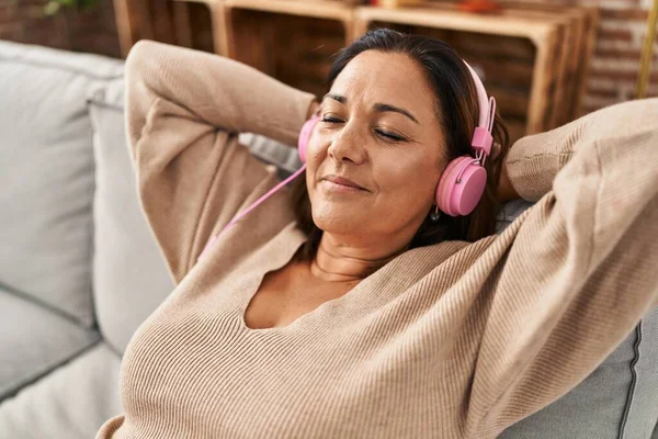 Middelbare Leeftijd Spaanse Vrouw Luisteren Naar Muziek Zitten Bank Thuis — Stockfoto