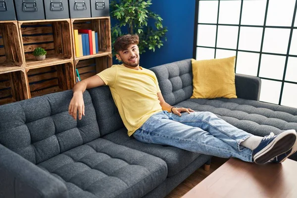 Jovem Árabe Homem Sorrindo Confiante Sentado Sofá Casa — Fotografia de Stock