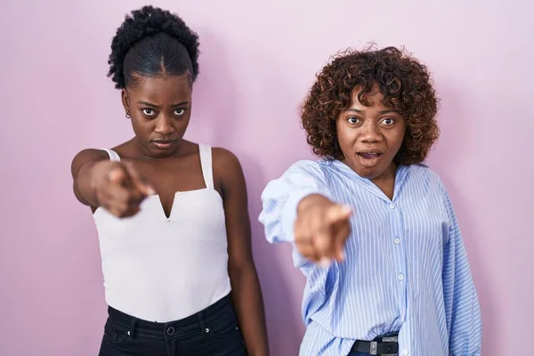 Две Африканки Стоящие Розовом Фоне Указывая Недовольство Разочарование Камере Злые — стоковое фото