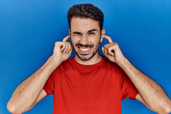 Mavi Arka Planda Kırmızı Tişört Giyen Sakallı Genç Bir Spanyol — Stok fotoğraf