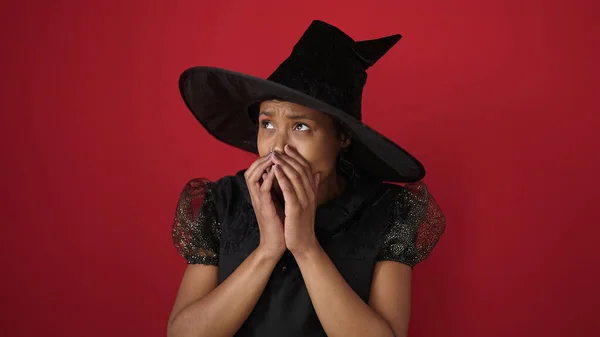 Африканская Американка Костюме Ведьмы Делает Жест Страха Изолированном Красном Фоне — стоковое фото