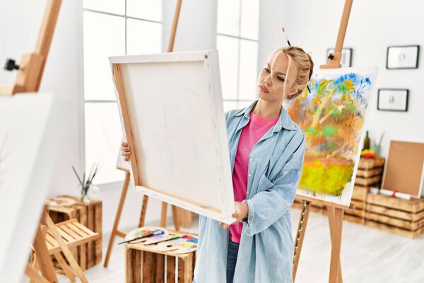 Молодая кавказская художница смотрит рисунок в художественной студии