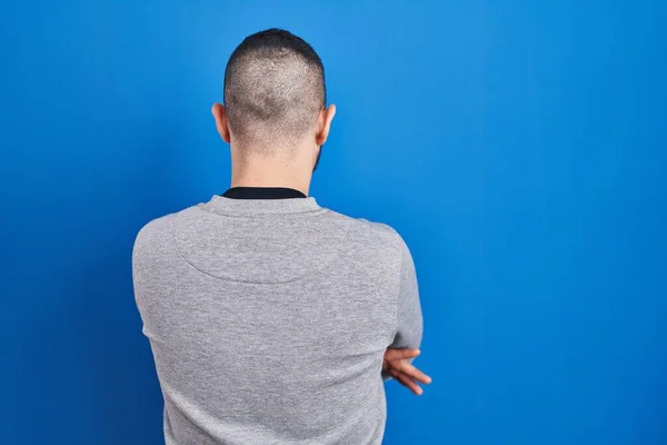 Hispanischer Mann Steht Auf Blauem Hintergrund Und Blickt Rückwärts Mit — Stockfoto