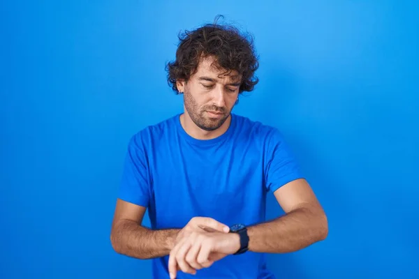 Jeune Homme Hispanique Debout Sur Fond Bleu Vérifier Heure Sur — Photo