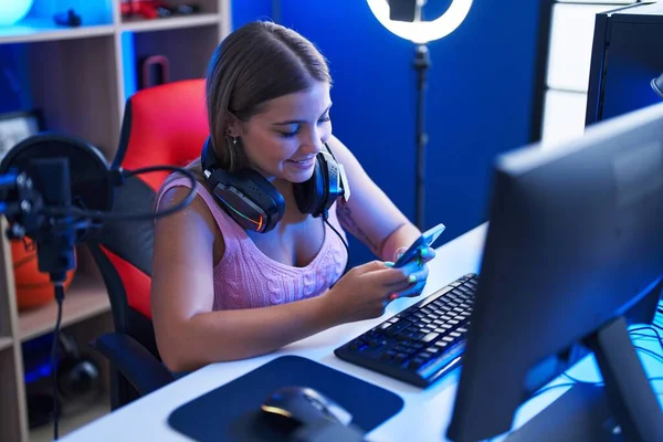 年轻美丽的惊慌失措的女人在游戏室用电脑和智能手机流口水 — 图库照片