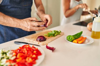 Orta yaşlı İspanyol çift mutfakta yemek pişiriyor.